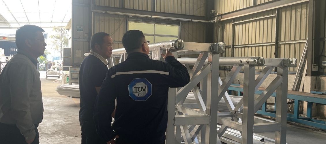 CE certification auditor reviewing aluminum truss strength and welding quality in production workshop